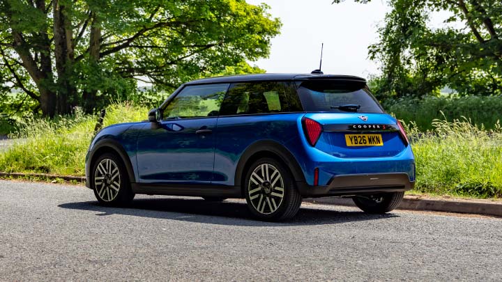 Blue MINI Driving On Country Road Rear Shot