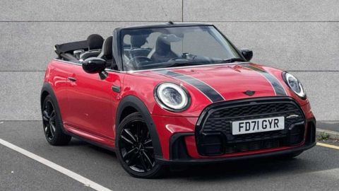Red MINI Convertible Sport parked in front of a grey wall