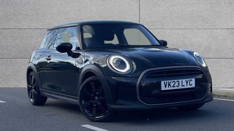 Black MINI Cooper Exclusive parked in front of a grey wall