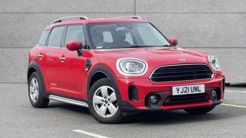 Red MINI Countryman Classic parked in front of a grey wall