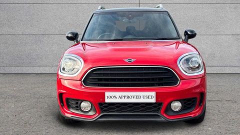 Red MINI Countryman Cooper Sport parked in front of a grey wall