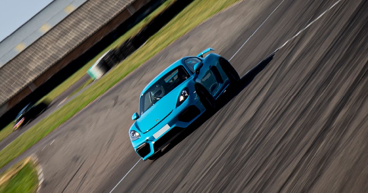 Blue Porsche Cayman GT4 Driving