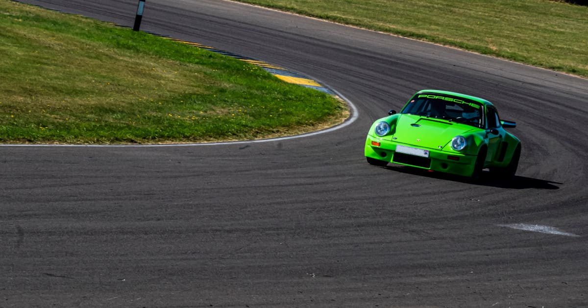 Green Porsche 911 Driving Front