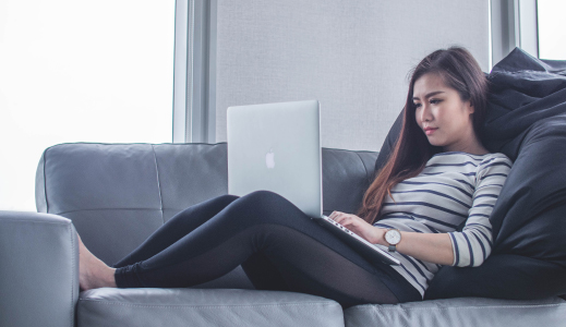 Person sat on the sofa browsing online.