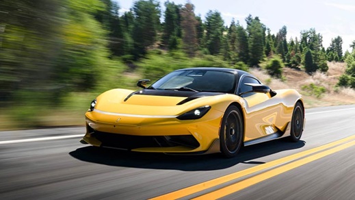 Close up of a yellow Pininfarina Battista driving down a country road