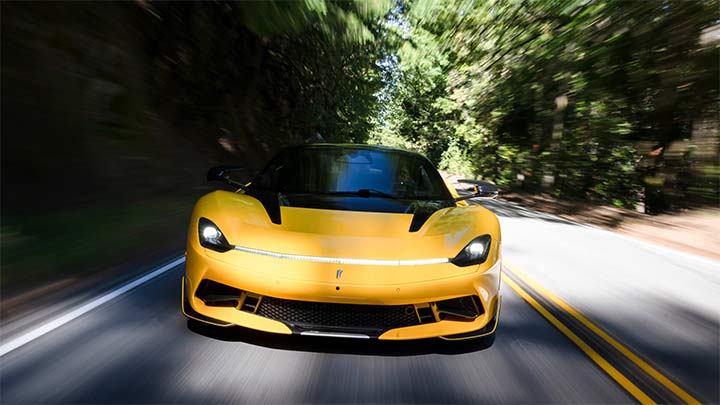 Close up of a yellow Pininfarina Battista driving down a country road