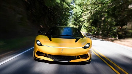 Close up of a yellow Pininfarina Battista driving down a country road