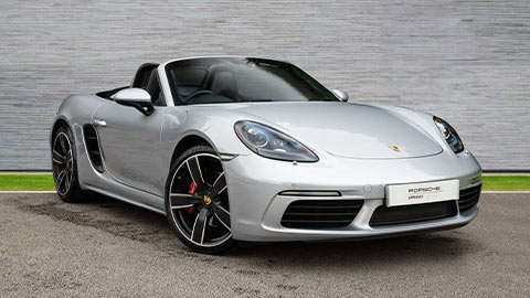 Grey Porsche 718 Boxster parked in front of a grey background