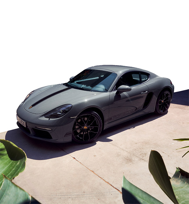 Grey Porsche 718 Cayman parked in front of a white background