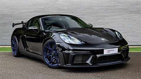 Black Porsche 718 Cayman GT4 RS parked in front of a grey background