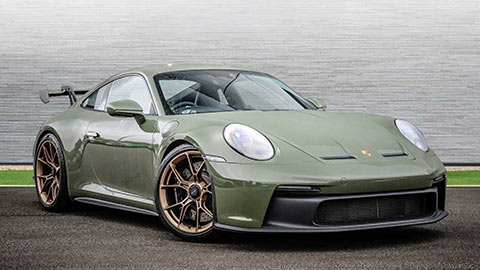 Green Porsche 911 GT3 parked in front of a grey background