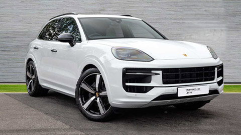 White Porsche Cayenne parked in front of a grey background