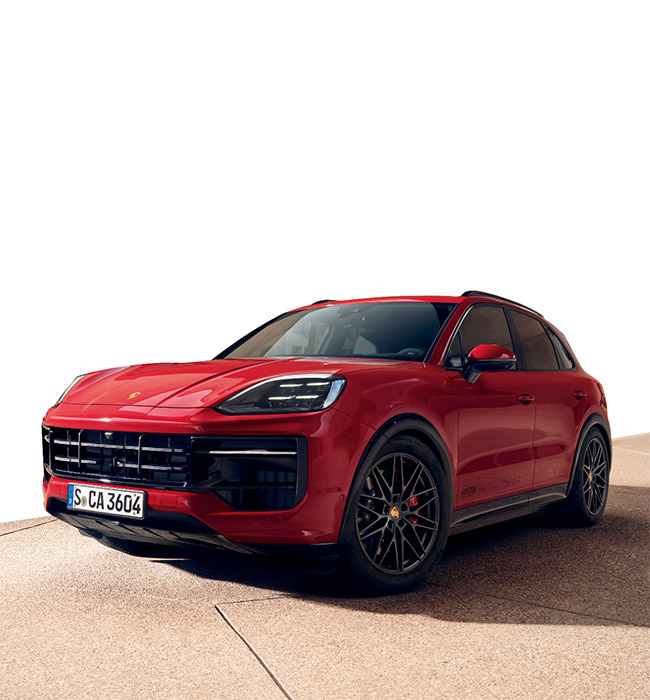 Red Porsche Cayenne parked in front of a white background