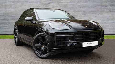 Black Porsche Cayenne GTS parked in front of a grey background
