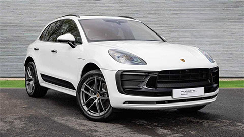 White Porsche Macan parked in front of a grey background