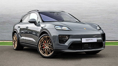 Grey Porsche Macan Electric parked in front of a grey background