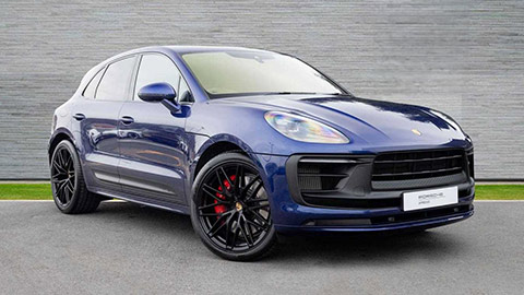 Blue Porsche Macan GTS parked in front of a grey background
