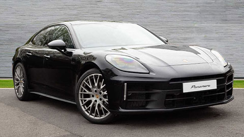 Black Porsche Panamera parked in front of a grey background