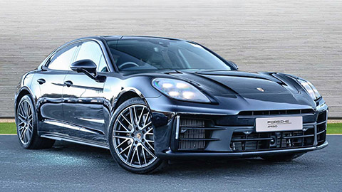 Black Porsche Panamera Turbo 4S e-Hybrid parked in front of a grey background