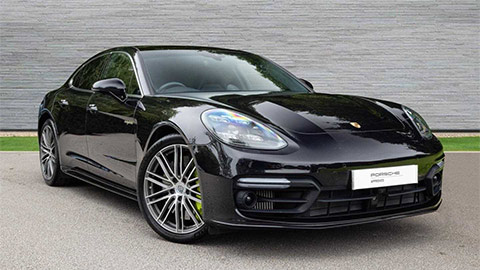 Black Porsche Panamera Turbo S e-Hybrid parked in front of a grey background