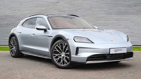 Grey Porsche Taycan Cross Turismo parked in front of a grey background