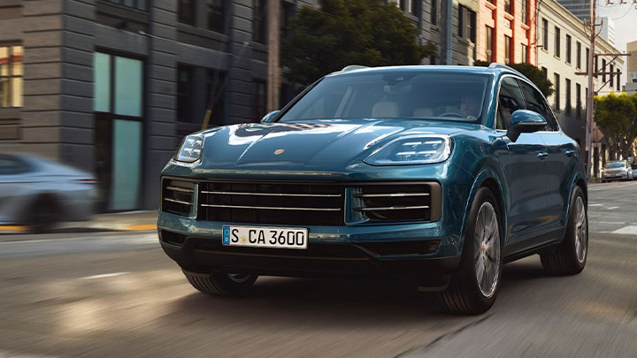 Blue Porsche Cayenne Driving On Road