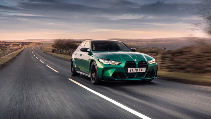 Green BMW Exterior Front Driving on Country Road at Dusk