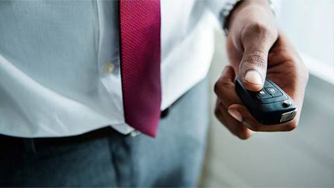 Man in a Suit Holding a Key Fob For a Car