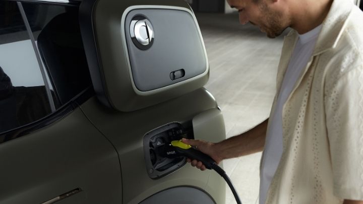 Man holding a charger onto smart #5 and waiting whilst the car charges