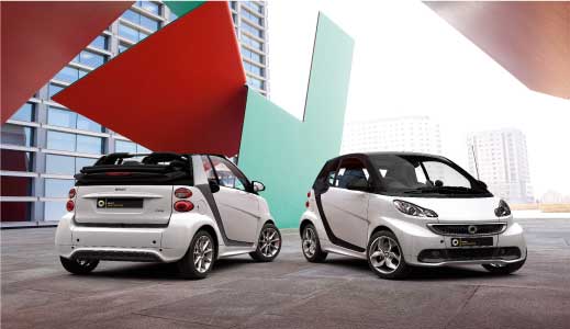 Two white approved used smart cars parked.