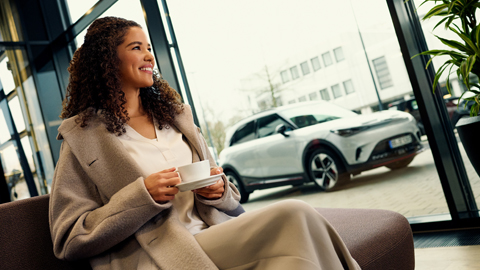 woman smiling next to smart vehicle