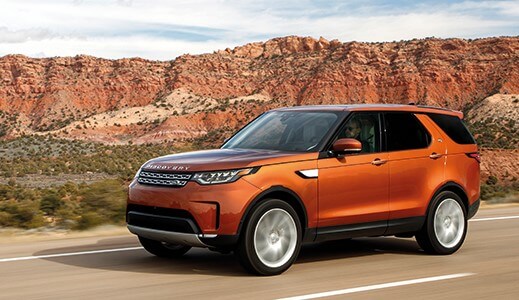 Orange Land Rover Discovery in the mountains.
