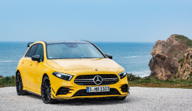 Front view of the yellow Mercedes-Benz AMG A35 parked by the sea.