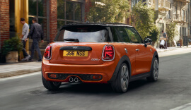 Back view of the orange MINI Hatch on the road.
