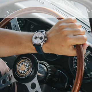 Hand on steering wheel of Jaguar Lightweight E-Type.